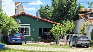 Un edificio con fachada verde y tejado rojo, con la señalización "LODECAMPO RECEPTION".