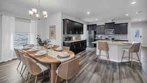 A modern kitchen with dark cabinets, stainless steel appliances, and a central island with bar stools. - Modern 4BR/2BA Home Near Airport, London HS & Local Businesses<br>Welcome to this newly built, professionally designed 4-bedroom, 2-bath home in Corpus Christi—perfect for business travelers, families, and groups of up to 8 guests. Enjoy a bright ope (Corpus Christi)