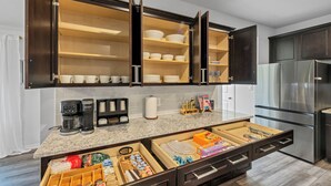 A kitchen with dark wooden cabinets, a stainless steel refrigerator, and a marble countertop. - Modern 4BR/2BA Home Near Airport, London HS & Local Businesses<br>Welcome to this newly built, professionally designed 4-bedroom, 2-bath home in Corpus Christi—perfect for business travelers, families, and groups of up to 8 guests. Enjoy a bright ope (Corpus Christi)