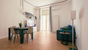 Een moderne woonkamer met een eethoek, een televisie en een bank.