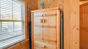 Un meuble en bois avec des tiroirs et un petit vase posé sur le dessus.
