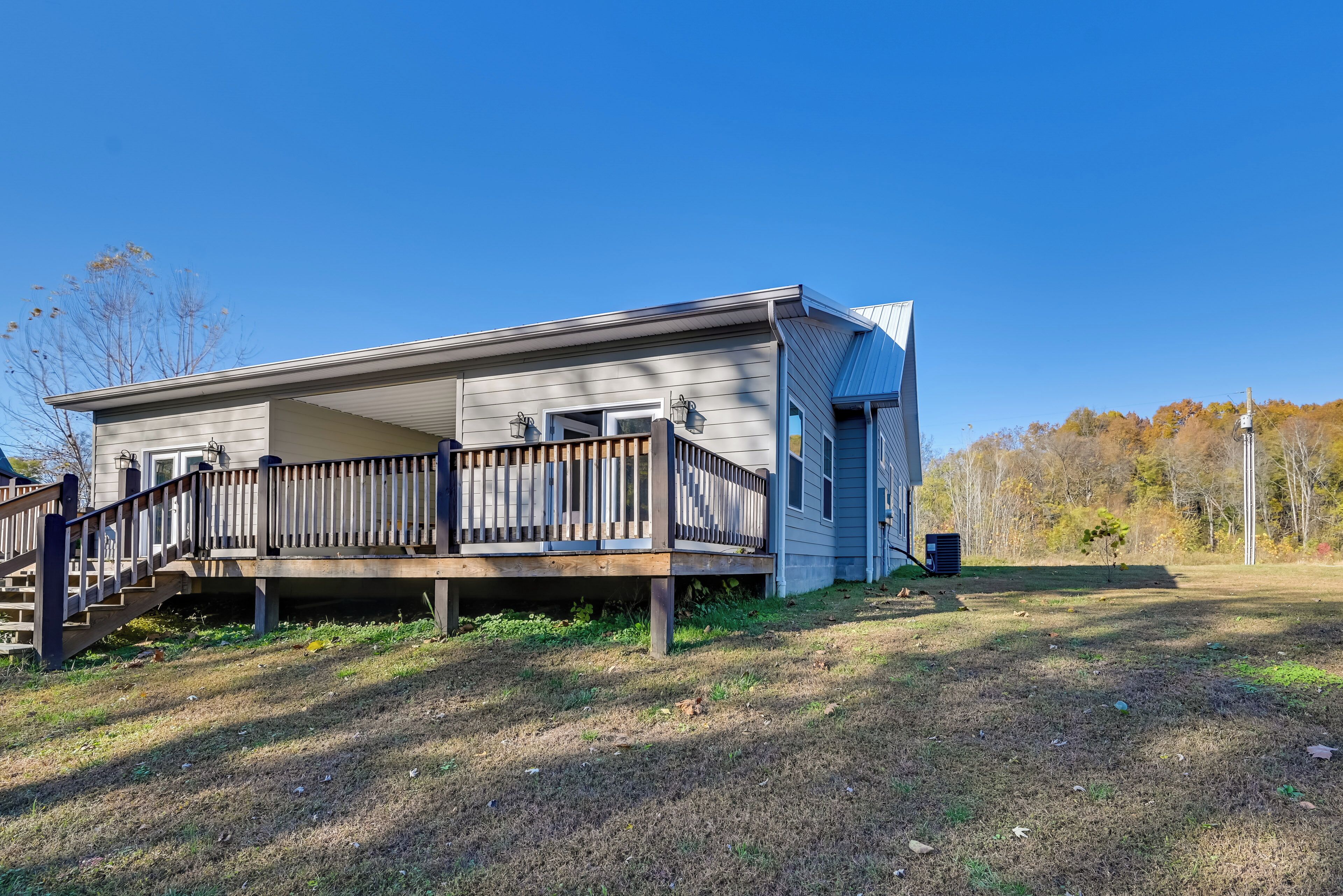 A single-story house with a wooden deck and a covered porch.