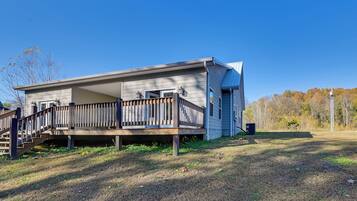 A single-story house with a wooden deck and a covered porch.