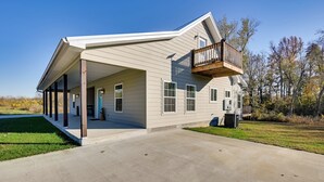 A two-story house with a covered porch, a balcony, and a large driveway. - Fish & Unwind! Rough River Hideaway w/ Deck (Falls of Rough)