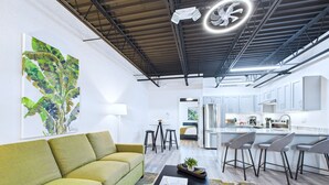 Een modern interieur met een bank, salontafel en een keukenbar met barkrukken.