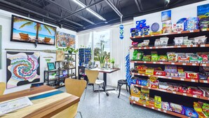 Ein hell erleuchteter Laden mit Regalen voller Snacks und einem Schreibtisch mit einem Computer.