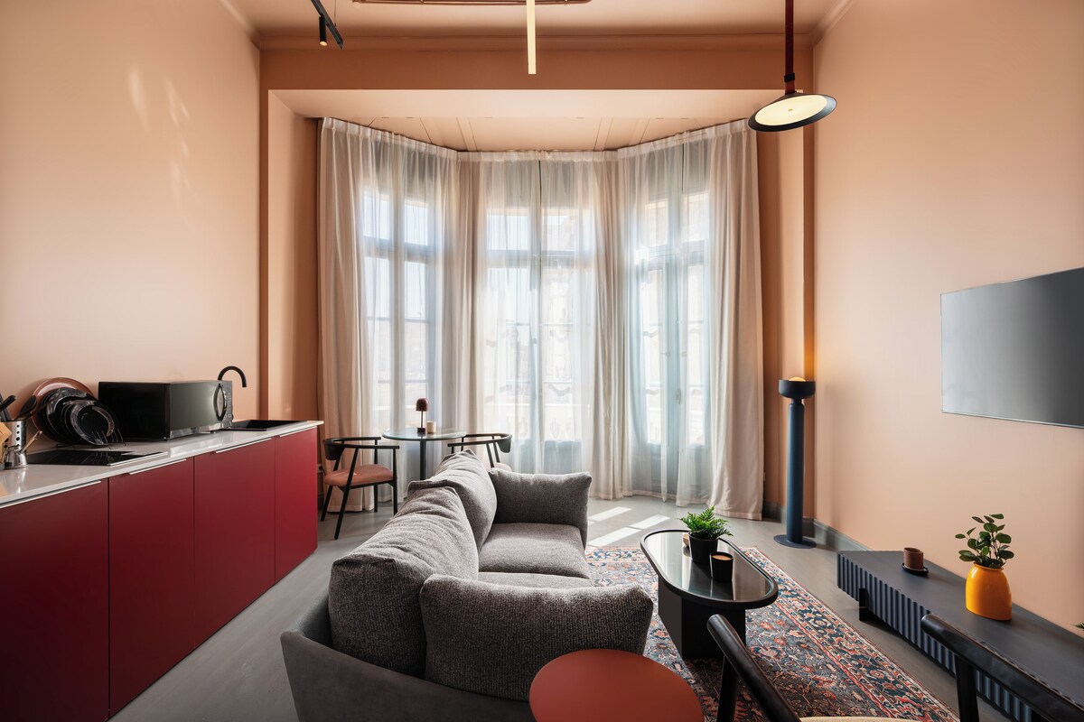 Una sala de estar moderna con un sofá, una mesa de centro y un comedor con una mesa y sillas.