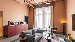 A modern living room with a sofa, chairs, a coffee table, and a small dining area. - Brassbell grey apartments Bidair House (Cairo)