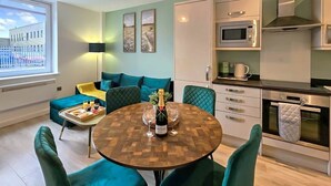 A modern kitchen with a microwave, oven, and a dining area with a round table and chairs.