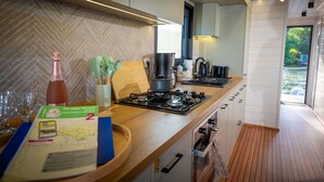 Una cocina moderna con cubierta de madera, estufa a gas, cafetera y un mapa sobre la mesa.