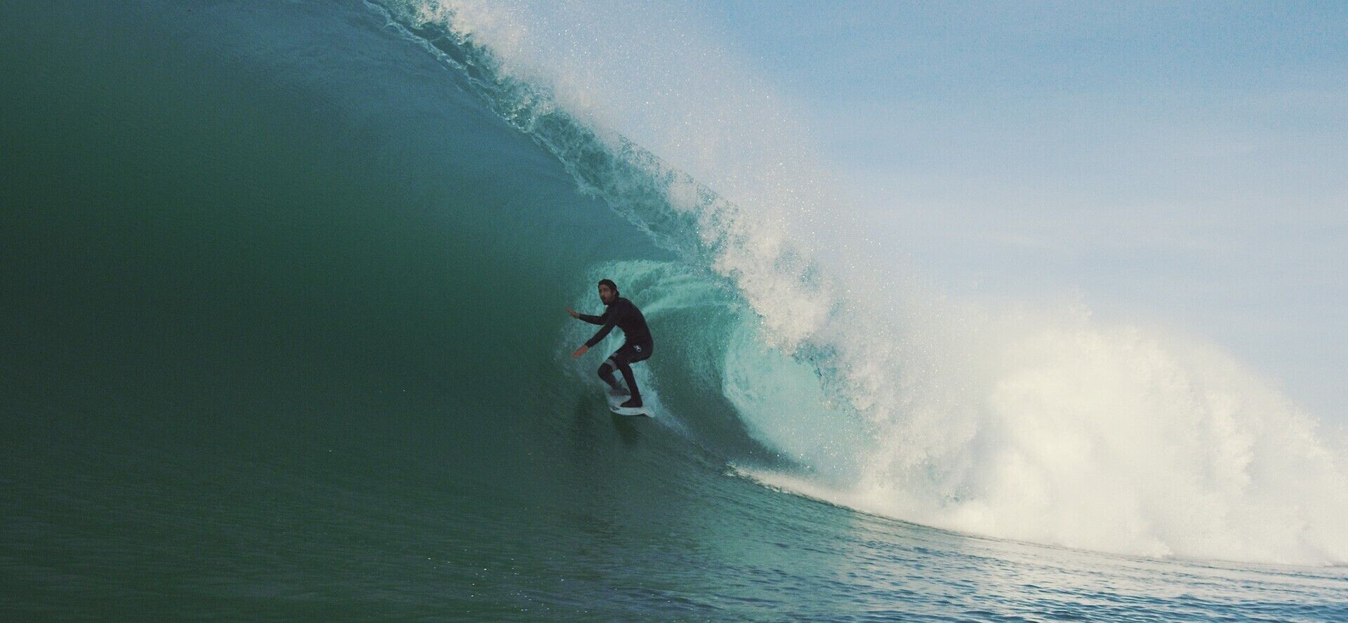 Una persona surfeando una ola grande.