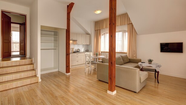 A spacious living area with a staircase, a kitchen, and a dining area. - Willa Drako (Międzyzdroje)