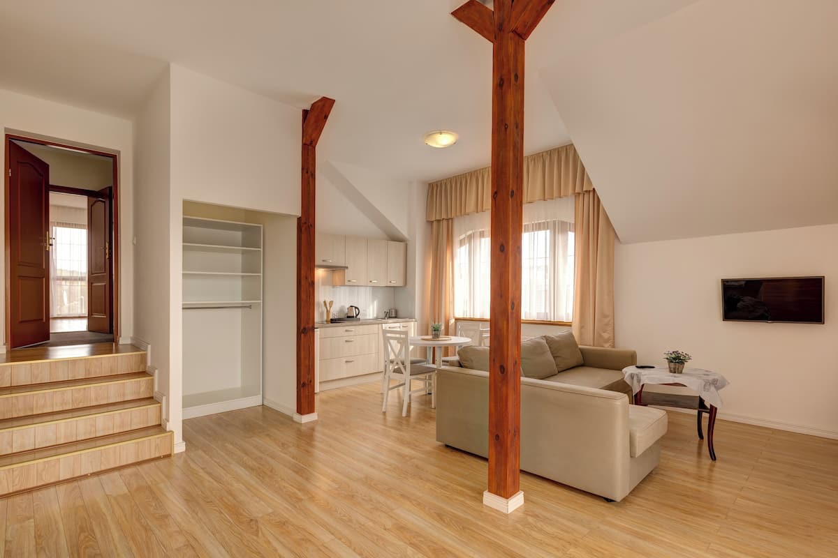 Un amplio espacio de estar con una escalera, una cocina y un comedor.
