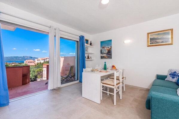 A modern apartment with a balcony, a dining area, and a living room. - Aironi 34 (Olbia)