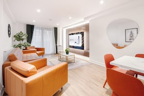 A modern living room with a sofa set, a coffee table, and a dining table with chairs. - LONDONERS│Marble Arch Serviced Apartments  (London)