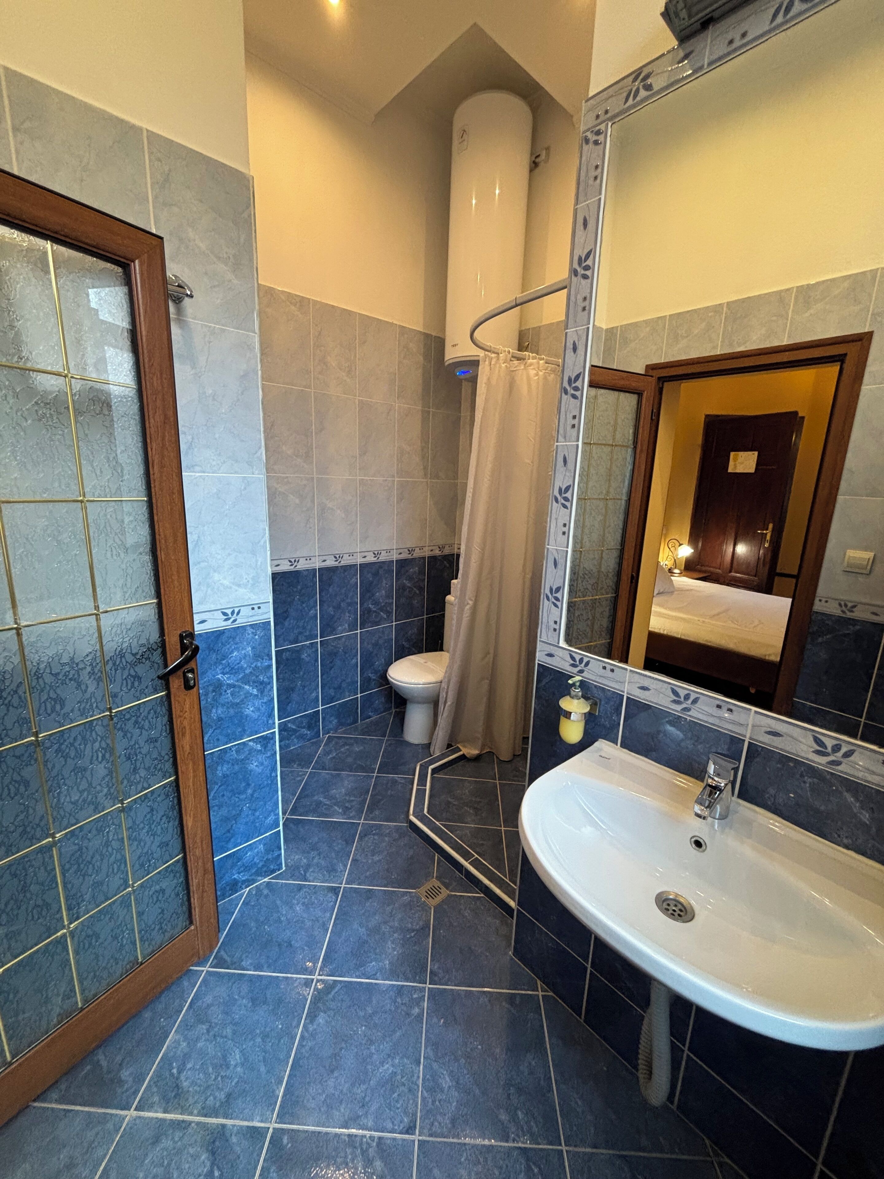 Une salle de bain avec douche, toilettes et lavabo.
