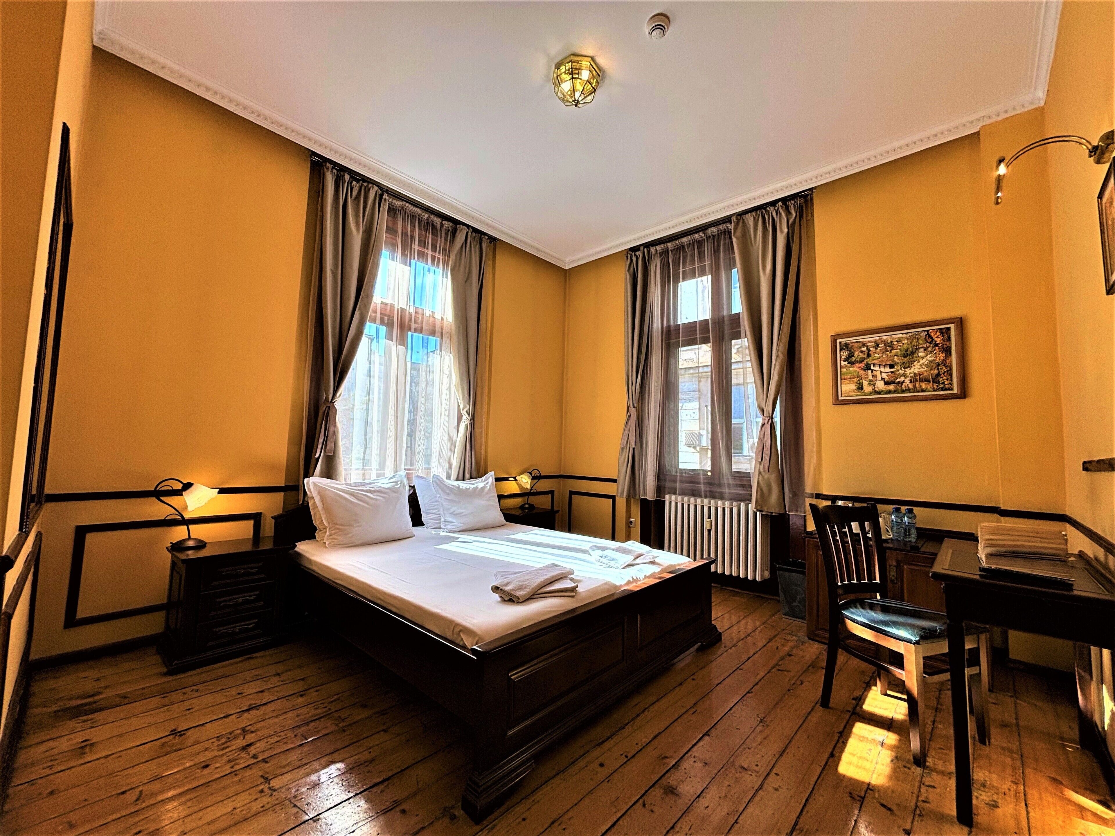 Ein Hotelzimmer mit einem hölzernen Bett, einem Schreibtisch und einem Stuhl.