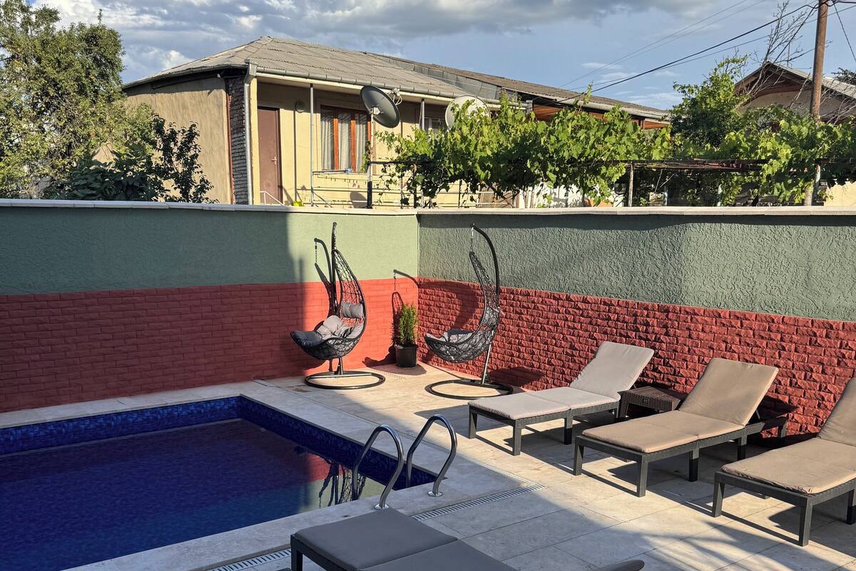 A rooftop pool area with lounge chairs and a small pool.