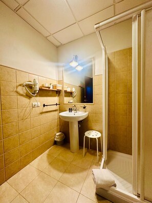 A bathroom with a sink, mirror, towel rack, and a shower area. - Villa Aemilius (Don Alvaro)