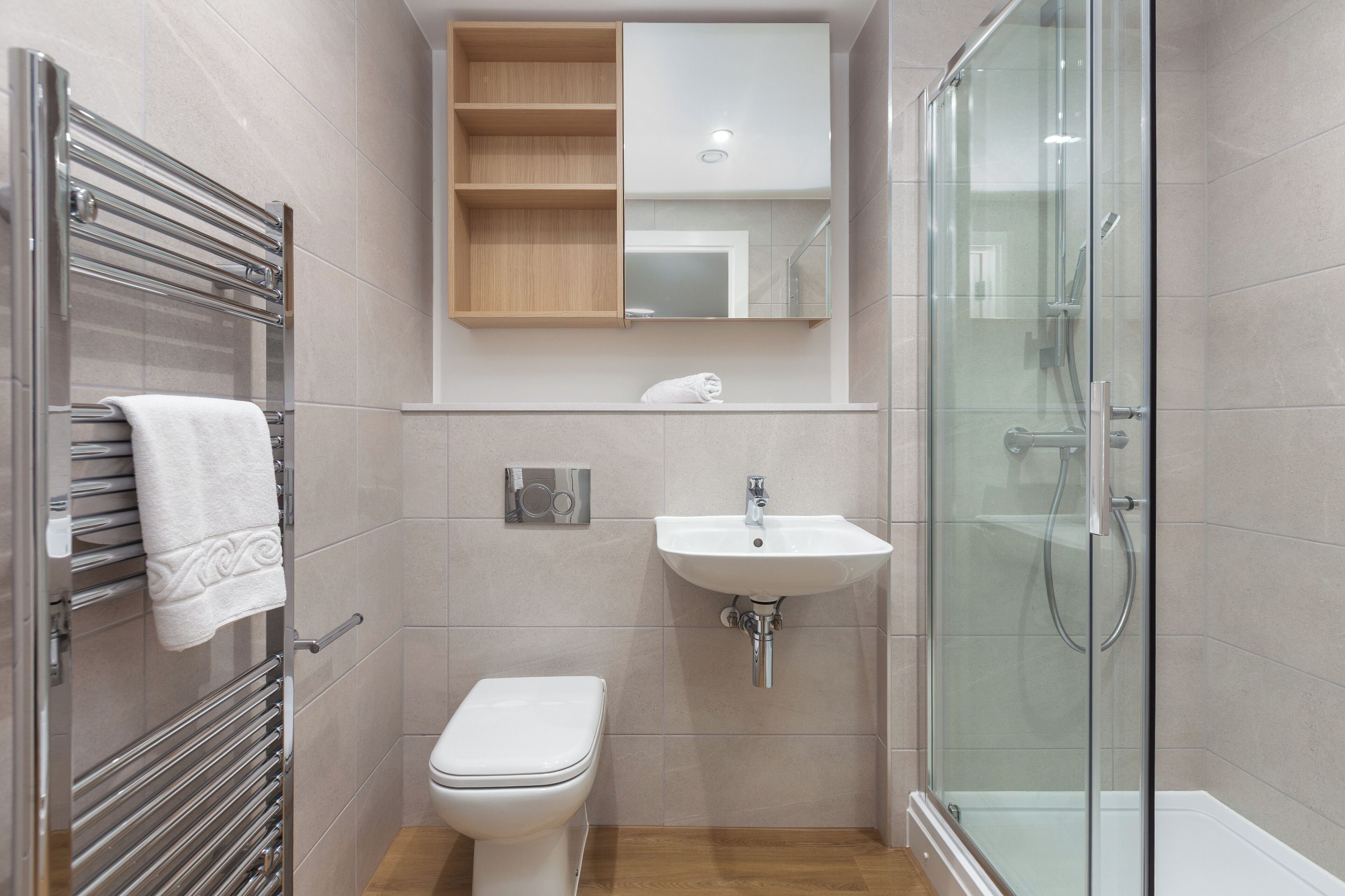 Ein modernes Badezimmer mit Duschkabine aus Glas, einem weißen Waschbecken und einer Toilette.