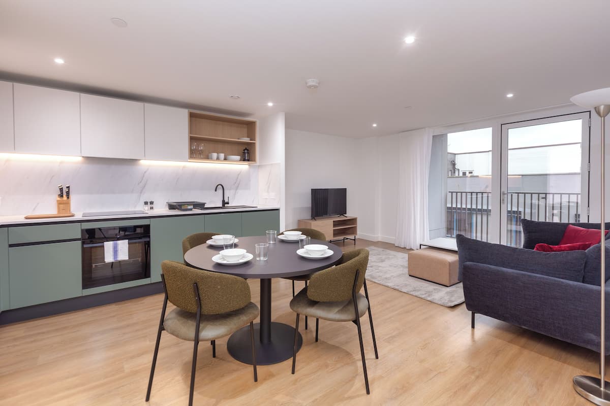 A modern apartment with a kitchen, dining area, and living room.