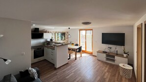 A modern apartment with a kitchen, dining area, and living room.
