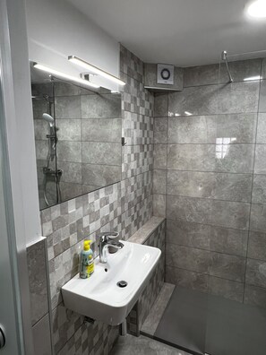 Een douche, een haardroger, handdoeken, toiletpapier