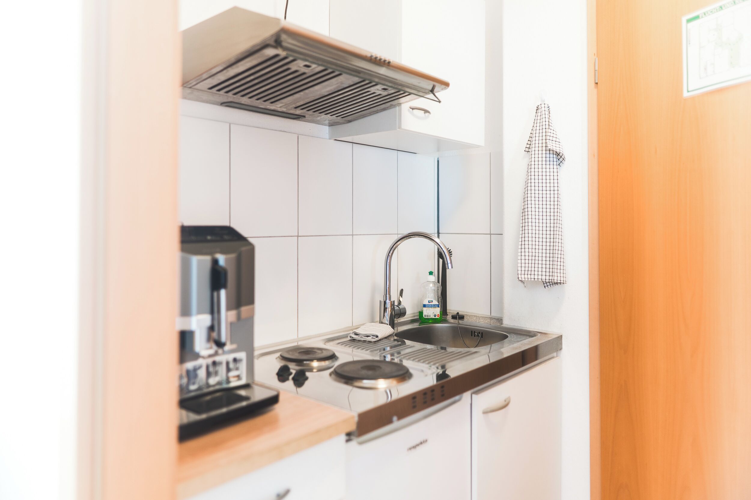 A compact kitchen with a stove, sink, and a small countertop.