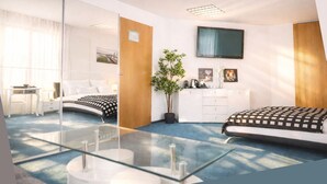 Moderni hotellihuone, jossa on suuri sänky, työpöytä, peili, televisio ja ruukussa oleva kasvi.