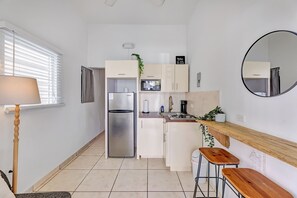 A compact kitchen with a refrigerator, microwave, stove, and a small dining area with stools. - Love Suite at Miramar, San Juan - 1 Bedroom (San Juan)