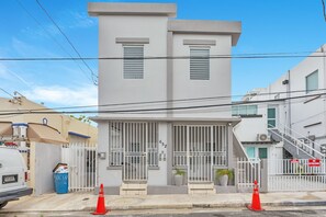 A modern two-story building with a gated entrance, a visible number '652' on the door, and a staircase to the right. - Beautiful 2 Bedroom in Miramar! (San Juan)