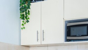 Una cocina con cafetera, microondas y fregadero.