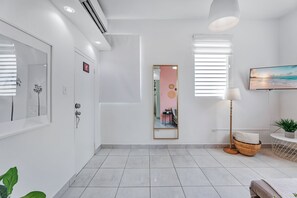Un baño moderno con un espejo grande, un inodoro y un lavamanos.