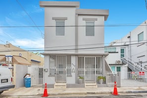 A modern two-story building with a gated entrance, a visible number '652' on the door, and a staircase to the right. - Centric, Spacious, Stylish Miramar Unit, Sleeps 4 (San Juan)