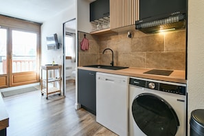 A compact kitchen with a dishwasher, a sink, and a built-in oven. - Apartment 'Les Marmottes - B12' with Mountain View and Balcony (Flumet)