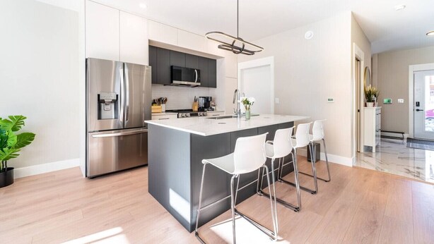 A modern kitchen with a central island, stainless steel appliances, and a minimalist design.