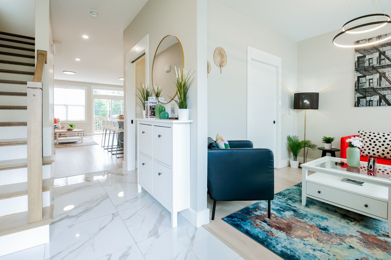 Un salon moderne avec un canapé bleu, une table basse blanche et un tapis aux couleurs vives.