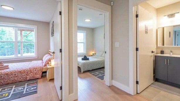 A modern hotel room with a large bed, a desk, and a view of the outdoors. - New Lux 2BR Bright & Spacious Walk-Out Suite in Halifax (Halifax)