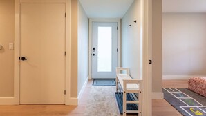 A hallway with a door, a small table, and a patterned rug. - New Lux 2BR Bright & Spacious Walk-Out Suite in Halifax (Halifax)