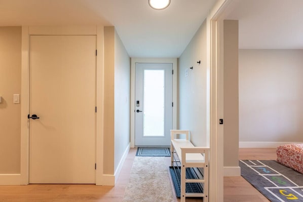A hallway with a door, a small table, and a patterned rug. - New Lux 2BR Bright & Spacious Walk-Out Suite in Halifax (Halifax)