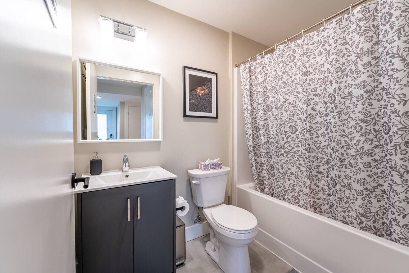 Een badkamer met een wastafel, spiegel, toilet en douchegordijn.