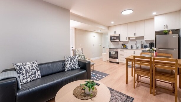 A modern apartment with a living room, dining area, and kitchen.