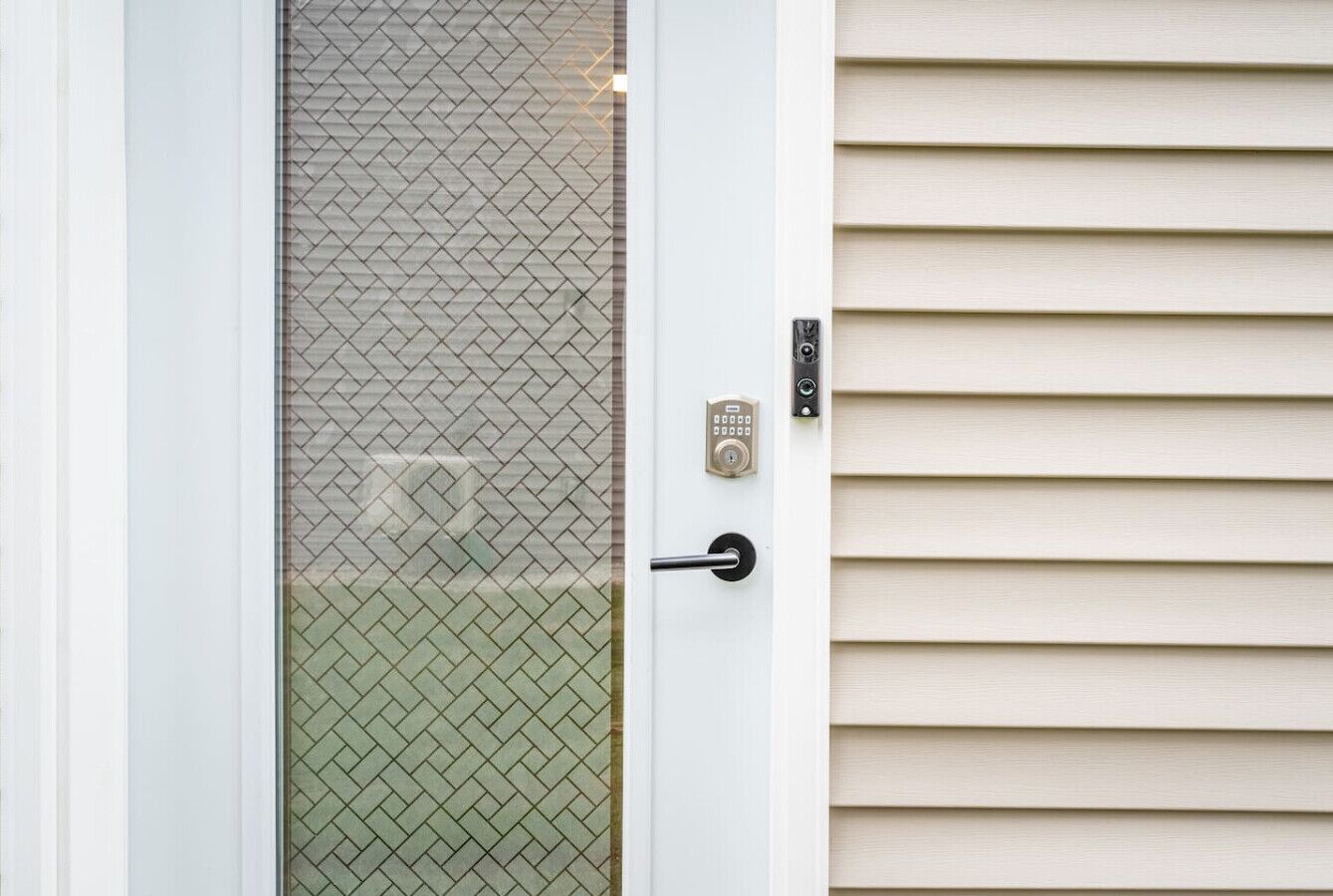 A door with a metal handle, a keypad lock, and a glass panel with a diamond pattern.
