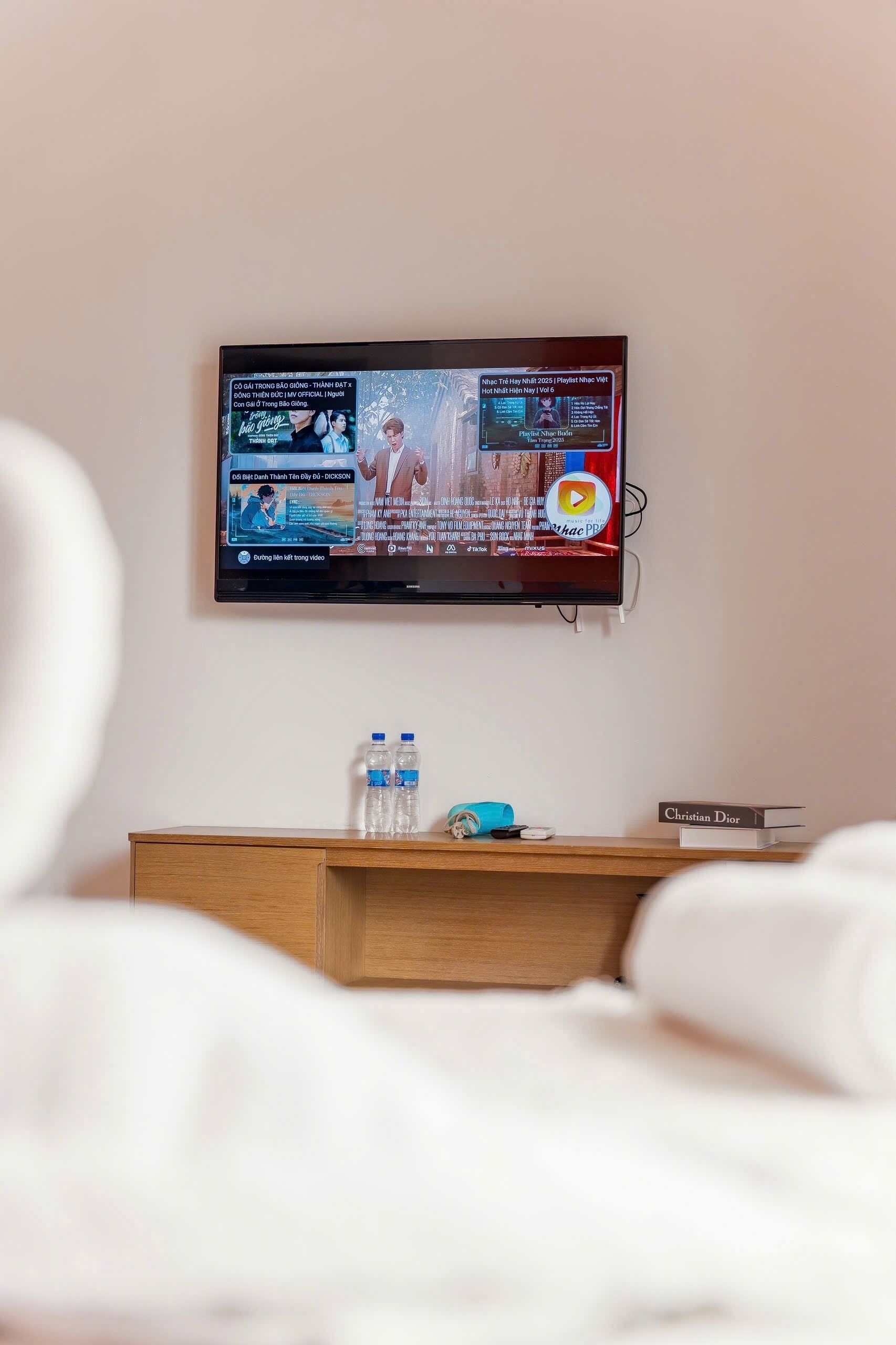 Een televisie aan de muur, waarop een muziekvideo wordt afgespeeld.