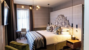 Een moderne hotelkamer met een groot bed, een bureau en een stoel.