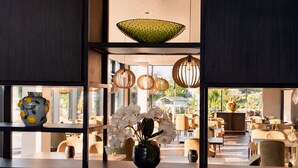 Un interior moderno con una zona de estar, jarrones decorativos y lámparas colgantes.