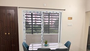A meeting room with a glass table, four chairs, and a potted plant.