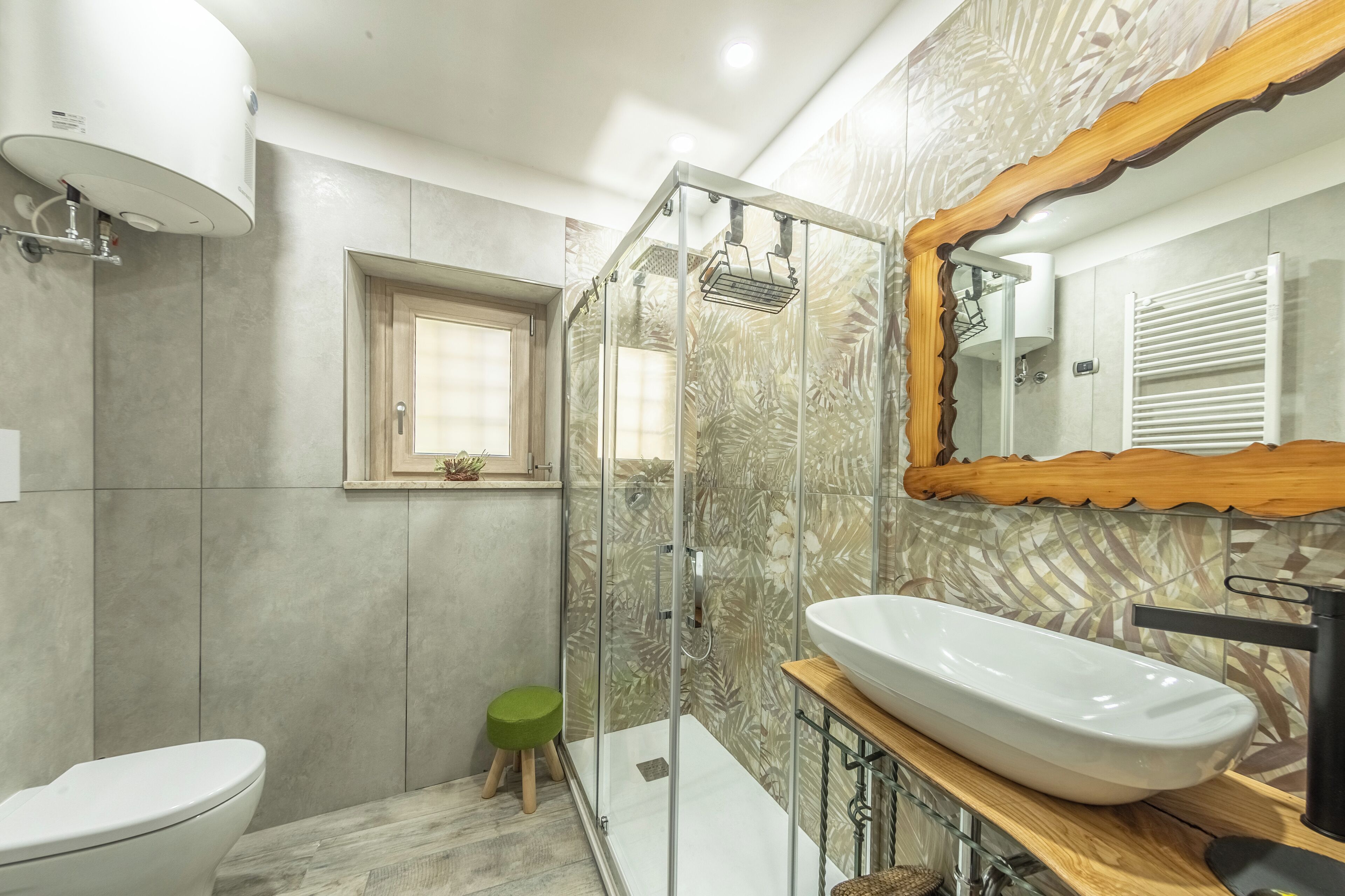 A modern bathroom with a glass-enclosed shower, a white sink, and a large mirror.