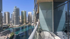 A high-rise building with a view of a cityscape and a body of water. - StayShort - Bright 1BR in JLT with Stunning Lake Views! (Dubai)