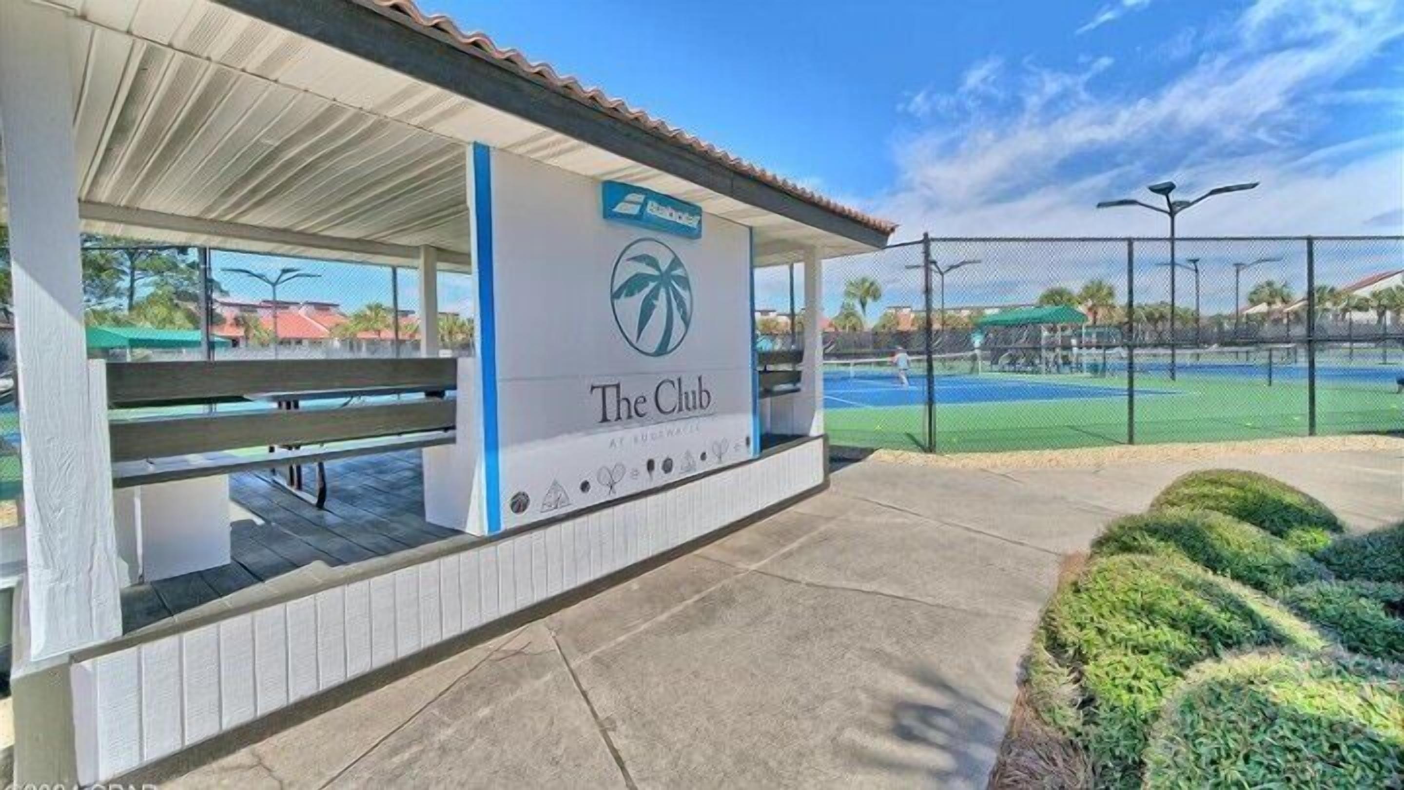 Zona de estar al aire libre cubierta con un letrero que dice "The Club" en un resort.